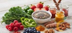 Composição elegante com alimentos funcionais variados, como frutas vermelhas, vegetais verdes, especiarias e sementes, representando abordagem integrada da nutrição funcional. Estética clean, tons suaves e luz natural.